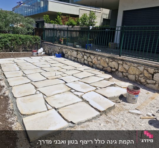 אבנים מרוצפות בגינה עם דליים וכלי עבודה